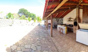 een terras met een keuken en een stenen vloer bij Rancho Andrade in Três Marias