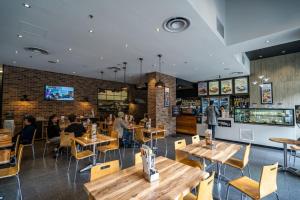 a restaurant with wooden tables and people sitting at tables at The North Star City View Jacuzzi Sauna in Adelaide