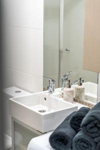 Baño blanco con lavabo y espejo en Huttside Luxury Central Secure Car park, en Adelaida