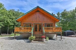 a log cabin with two benches in front of it at Chalet Le Crépuscule SPA, BILLARD, FOYER, SENTIERS PRIVES in Chertsey