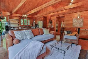 a living room with a couch and a table at Chalet Le Crépuscule SPA, BILLARD, FOYER, SENTIERS PRIVES in Chertsey +70 photos