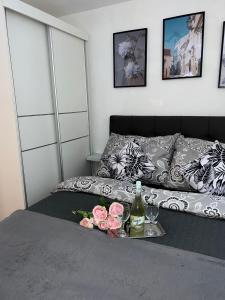 a bed with a tray with a bottle of wine and flowers at Elit Tuzla in Tuzla