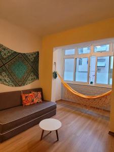 uma sala de estar com um sofá e uma rede de descanso em Apê Turquesa, 190 m da praia do Leme no Rio de Janeiro