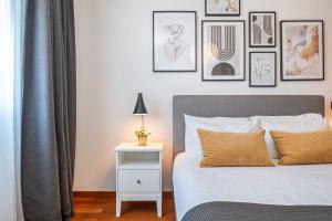 a bedroom with a bed and framed pictures on the wall at Ficcus Home in Caniço