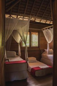 two beds in a room with mosquito nets at Rancho do Kite Villas in Prea