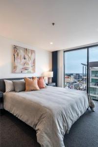 um quarto com uma cama grande e uma janela grande em Onyx on North Tce CBD Penthouse Pool Parking em Adelaide