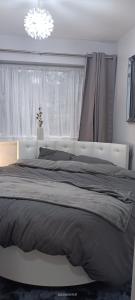Un dormitorio con una cama grande y una lámpara de araña. en Lister Park Bradford Stylish 1bed Coach House - Quiet & Tranquil Cottage & Parking en Shipley