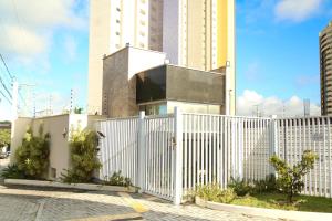 uma cerca branca em frente a um edifício em Casa a 560 metros da Praia de Ponta Negra em Natal