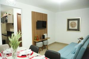 Casa a 560 metros da Praia de Ponta Negra في ناتال: غرفة معيشة مع أريكة زرقاء وطاولة