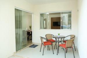 uma sala de jantar com uma mesa, cadeiras e um espelho em Casa a 560 metros da Praia de Ponta Negra em Natal