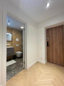 a bathroom with a toilet and a wooden door at Žemaičiai in Panevėžys +7 photos