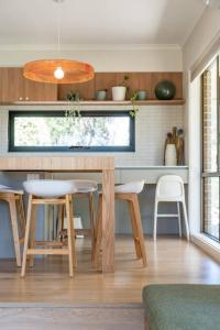 Adelaide Hills Retreat - Surrounded by Nature في Ironbank: مطبخ مع طاولة وكراسي في غرفة