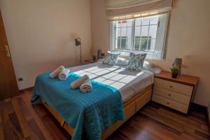 1 dormitorio con 1 cama grande y toallas. en The Beach Apartment by Hello Homes Sitges, en Sitges