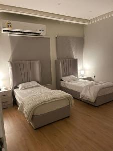 una camera con due letti e un condizionatore d'aria di Family Furnished Apartment in Khobar a Al Khobar
