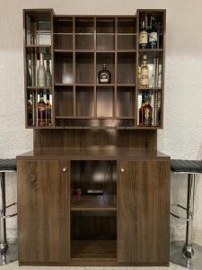 a wooden cabinet with bottles of alcohol in it at SANDS HOMES IKOYI in Lagos