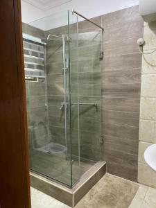 a shower with a glass door in a bathroom at SANDS HOMES IKOYI in Lagos