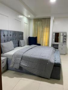 拉各斯的住宿－SANDS HOMES IKOYI，一间卧室配有一张大床和一把椅子