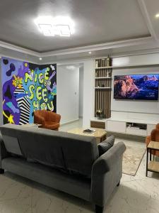 a living room with a couch and a flat screen tv at SANDS HOMES IKOYI in Lagos