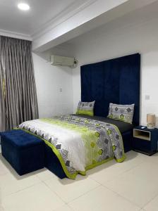 a bedroom with a large bed with a blue headboard at SANDS HOMES IKOYI in Lagos