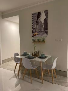 阿可賀巴的住宿－Family Furnished Apartment in Khobar，一间配备有白色桌椅的用餐室