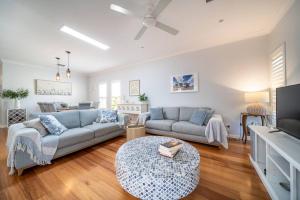 a living room with a couch and a tv at Azure on Anderson Family home in Henley Beach South