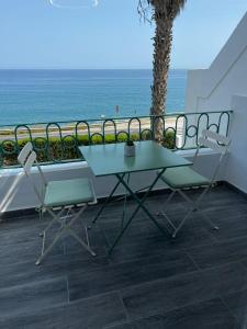 een tafel en 2 stoelen op een balkon met uitzicht op de oceaan bij Casa Blanca in Torrox Costa