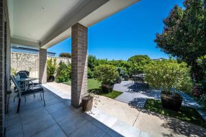 a patio with a table and chairs on a house at Azure on Anderson Family home in Henley Beach South