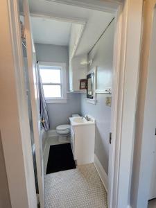 a small bathroom with a toilet and a sink at Cozy Vintage Bungalow @Mills50 District in Orlando