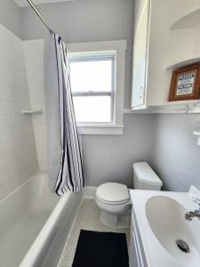 a white bathroom with a toilet and a sink at Cozy Vintage Bungalow @Mills50 District in Orlando +11 photos