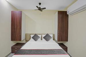 - une chambre avec un lit et un ventilateur de plafond dans l'établissement Meera Eternity, à Noida