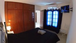 1 dormitorio con cama negra y ventana en Atalaya en Salta