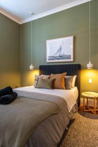 a bedroom with a large bed with a painting on the wall at Wisteria Cottage c1880 in Adelaide