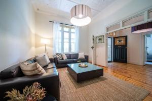 a living room with a couch and a coffee table at The Oxford Hyde Park 4BR Cottage in Unley