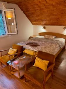 a bedroom with a bed and a table and chairs at Vila Vera Novosadska 15 in Velika Remeta