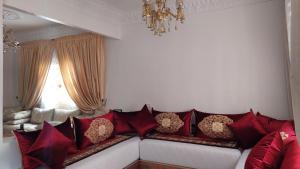 a living room with a couch with red pillows at Emplacement idéal in Tangier
