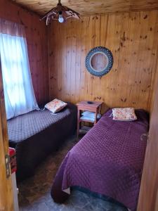 a bedroom with two beds and a table with a mirror at Cabaña Los Abuelos in Coronel Moldes