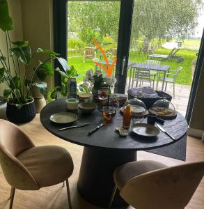 NieuwkoopにあるB&B De Meijeの椅子付きの部屋にテーブルと食べ物を用意しています。