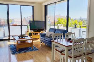 ein Wohnzimmer mit Sofa und Fernseher in der Unterkunft The East Ender 1BR Balcony City View in Adelaide + 10 Fotos