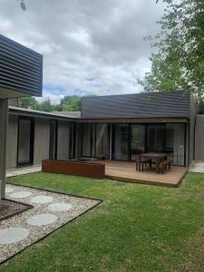 uma casa com um deque de madeira com uma mesa de piquenique em The Architects House Villa 1 2BR em Hahndorf