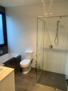 uma casa de banho com um WC e uma cabina de duche em vidro. em The Architects House Villa 1 2BR em Hahndorf