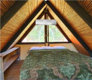 1 dormitorio con cama y ventana grande en Las Plumas de Cabuya en Cabuya