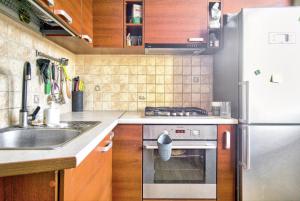 a kitchen with a sink and a stove and a refrigerator at Room near downtown and airport in Vilnius