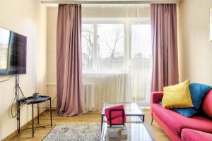 a living room with a red couch and a window at Room near downtown and airport in Vilnius
