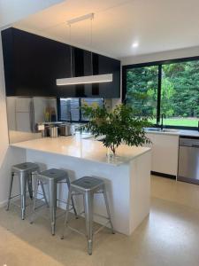 a kitchen with a large white counter with stools at The Architects House Villa 1 and 2 in Hahndorf