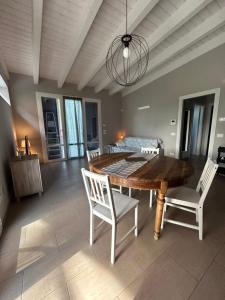 uma sala de jantar com uma mesa de madeira e cadeiras brancas em Casetta rossa em Lesignano deʼ Bagni