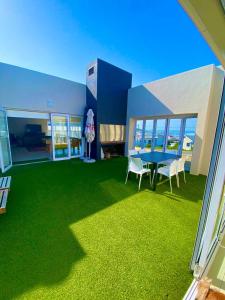 a room with a blue table and chairs and green grass at Poolstraat 16 in Agulhas