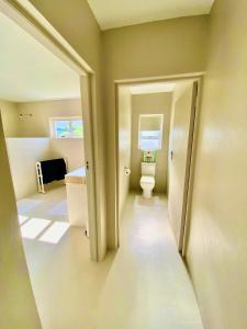 an empty bathroom with a toilet and a sink at Poolstraat 16 in Agulhas