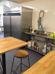 uma cozinha com um frigorífico de aço inoxidável e uma mesa de madeira em Highlander Hostel em Kyle of Lochalsh