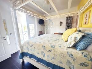 Schlafzimmer mit einem Bett mit einer blauen und weißen Bettdecke in der Unterkunft Inn on the Avenue in New Smyrna Beach