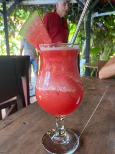 ein Getränk mit einer Scheibe Wassermelone in einem Glas auf dem Tisch in der Unterkunft MisMiriam in Tortuguero